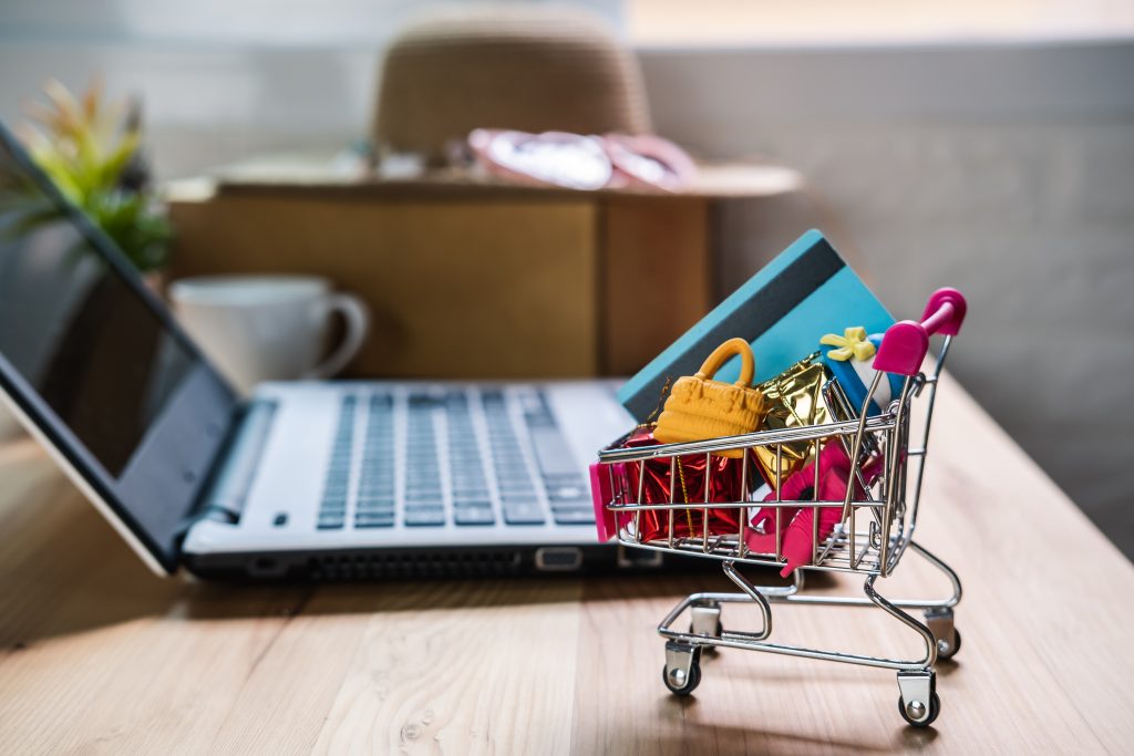 Shopping cart with credit card and woman accessories with laptop, Online shopping concept