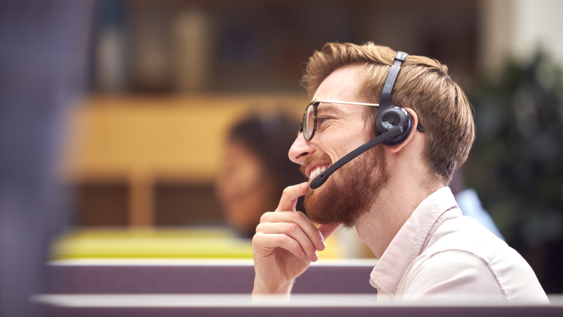 IT service-in-cubicle-wearing-headset-talking-to-client